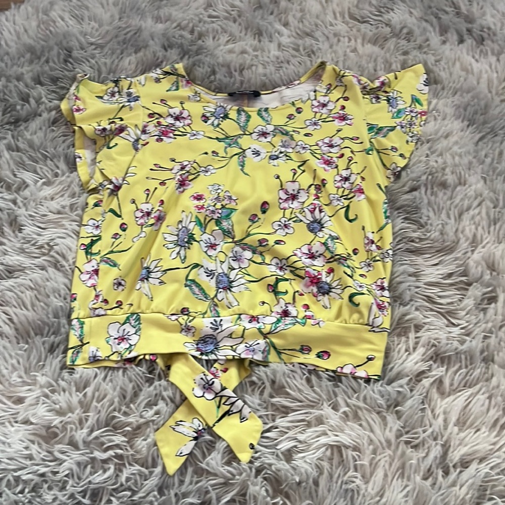 This is such a cute top it has types in the back this is a floral yellow top!!